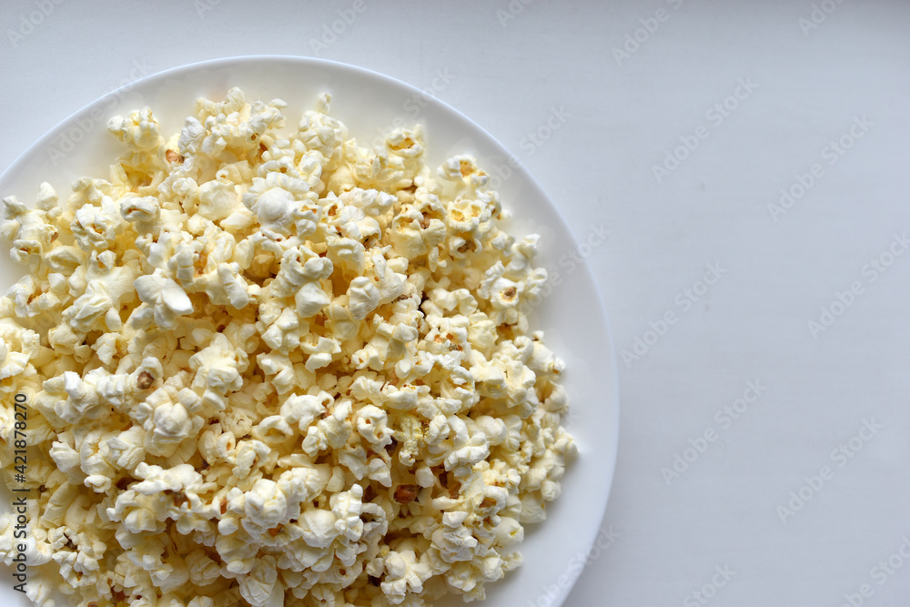 Delicious popcorn on a white plate close-up