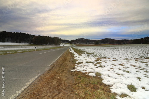 Fototapeta Naklejka Na Ścianę i Meble -  road through fields and woodlands in winter