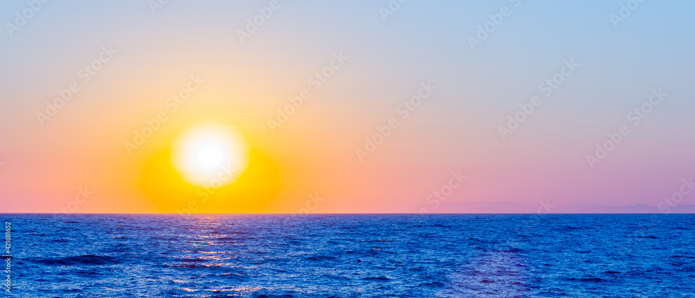 Orange sunset over sea. Bright sun over the sea horizon. Concept: vacation and relax