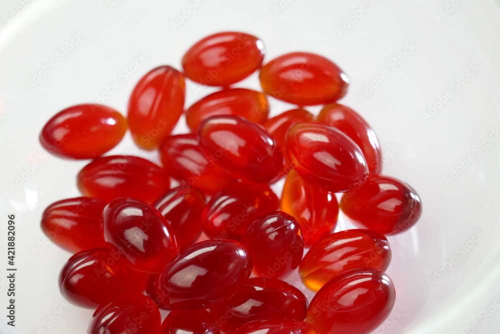 Krill oil capsules. Red gelatin capsules with krill oil on a white background.Source of omega fatty acids.Dietary supplement .Healthy food.krill oil supplements Krill oil capsules. Red gelatin capsules with krill oil on a white background.Source of omega fatty acids.Dietary supplement .Healthy food.krill oil supplements
