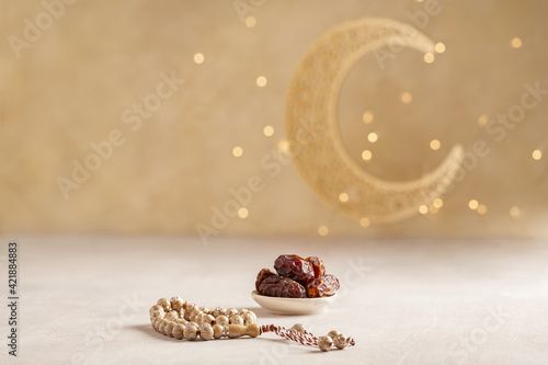 Ramadan kareem background . Golden Ramadan moon decor with Islamic rosary beads and dates fruit. photo