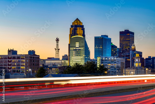 Downtown Des Moines skyline with light trails at sunset.