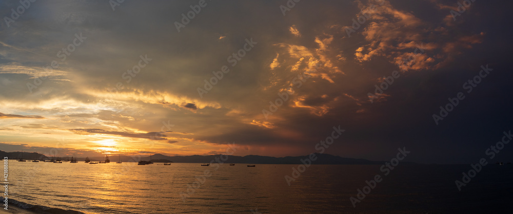 panoramic of the Sunset on a tropical beach with pirate boats in the background, located on the beach of Cachoeira do Bom Jesus, Canasvieras, Ponta das Canas, Florianópolis, Santa Catarina