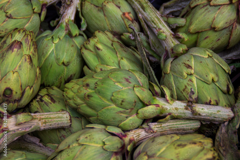 Obraz premium A lot of healthy artichokes in a food market