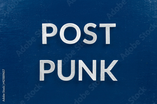 words post punk laid with aluminium letters over blue painted board surface photo