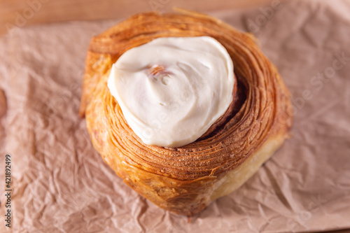 Cinnamon bun made with butter laminated croissant dough and cream cheese icing