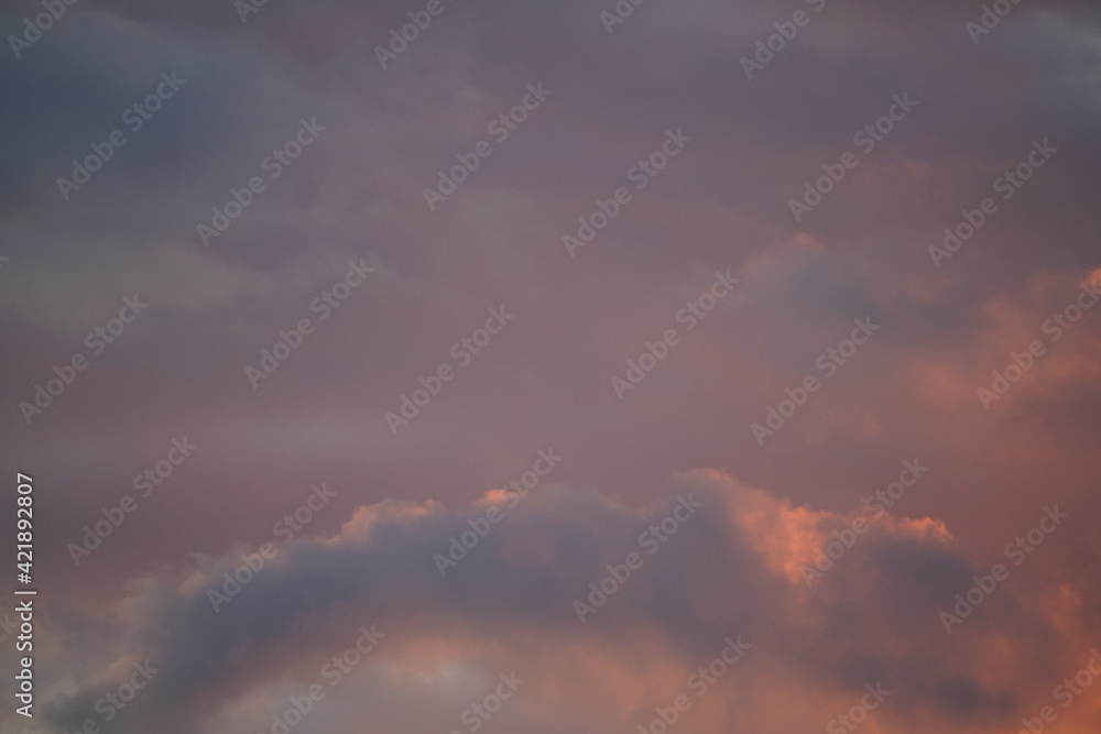 Wolken Hintergrund in blauer und orangener Tönung bei einem Sonnenuntergang