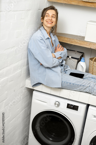 Woman with phone in the laundry room