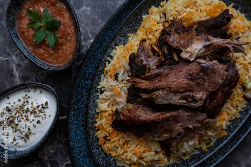 Konstfotografi A plate of kabsa rice and grilled lamb and two small plates of Yogurt and hot sauce