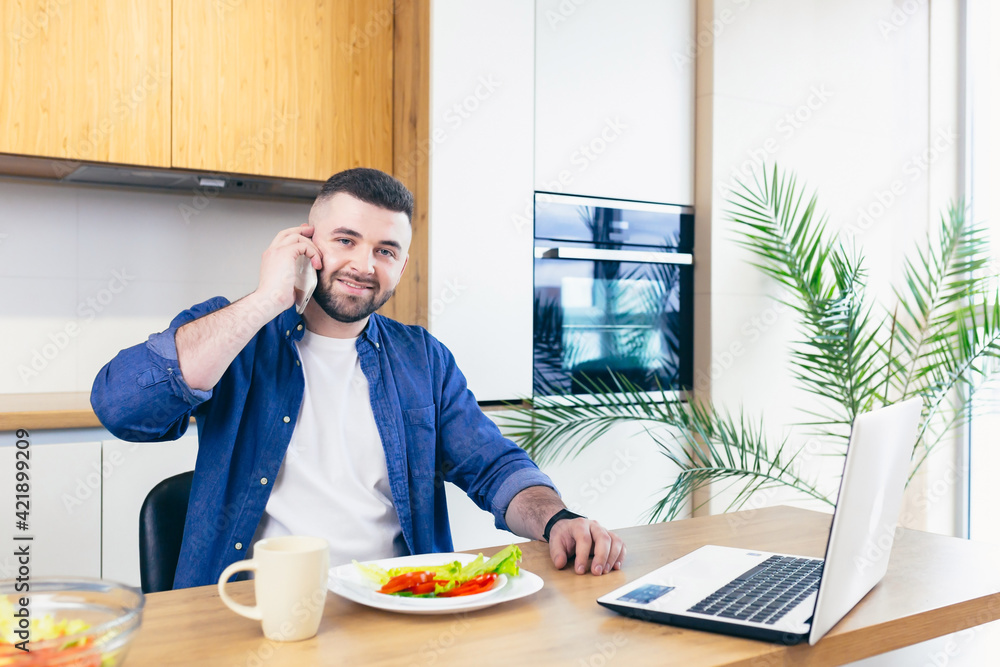 Young male businessman having breakfast at home, and doing business, on a notebook Young male businessman having breakfast at home, and doing business, on a notebook