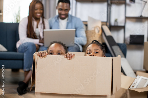 Two kids sitting inside cardboard box at new flat © sofiko14