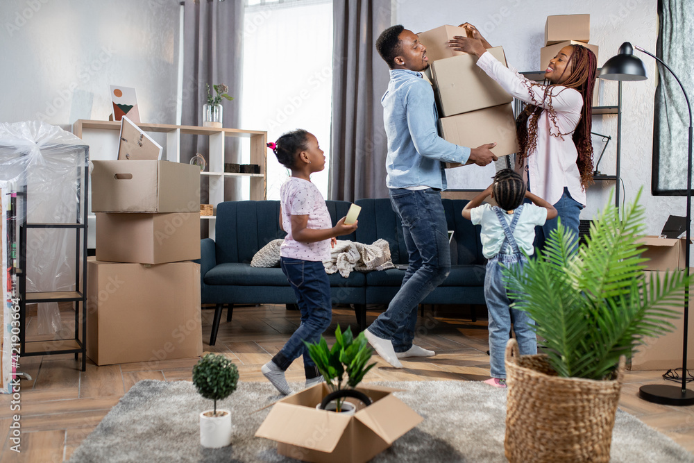 Afro american parents and kids packing boxes for moving Afro american parents and kids packing boxes for moving