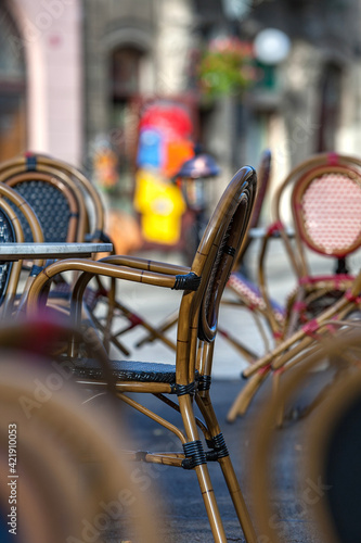 An empty summer outdoor area of a restaurant or cafe in a historic downtown is closed during lockdown. Tables and chairs without visitors. Challenging times business in HoReCa during a pandemic. photo