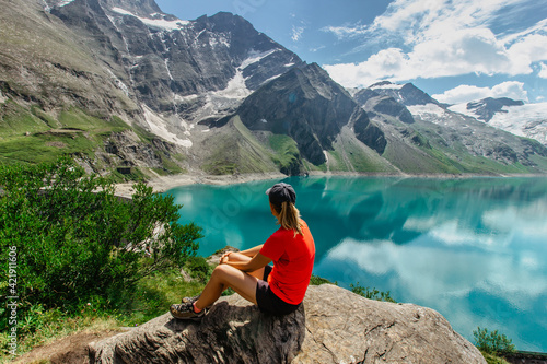 Foto Sporty Girl sitting enjoying beautiful view of mountain lake near Kaprun,Austria