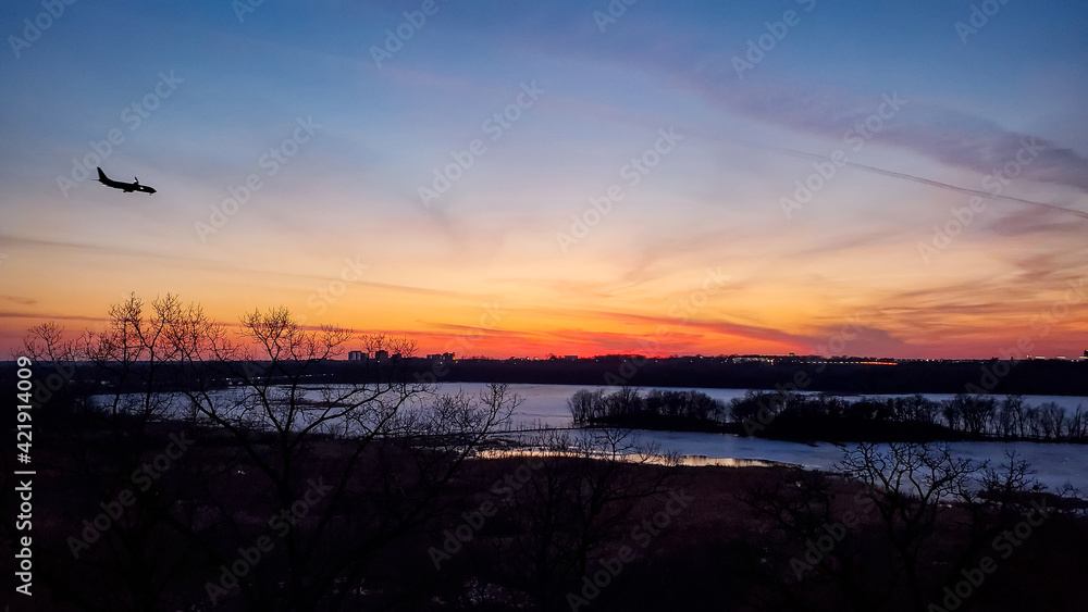 Sunset over the lake as a plane is landing Stock Photo | Adobe Stock