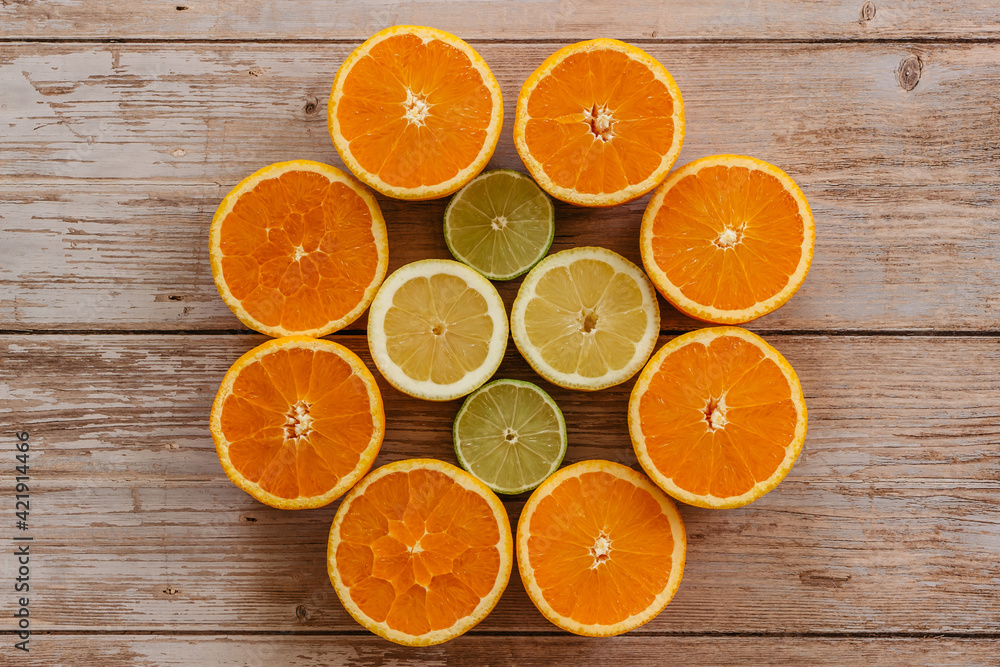 Oranges,limes and lemons slides on wooden table view from above. Beautiful background with fresh fruit half cut.Healthy eating vitamin C.Summer tropical fruits food concept flat lay. Oranges,limes and lemons slides on wooden table view from above. Beautiful background with fresh fruit half cut.Healthy eating vitamin C.Summer tropical fruits food concept flat lay.