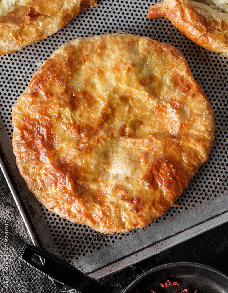 Traditional homemade Romanian and Moldovan round pies - Placinta, served on a plate, dark background. Bakery products Traditional homemade Romanian and Moldovan round pies - Placinta, served on a plate, dark background. Bakery products