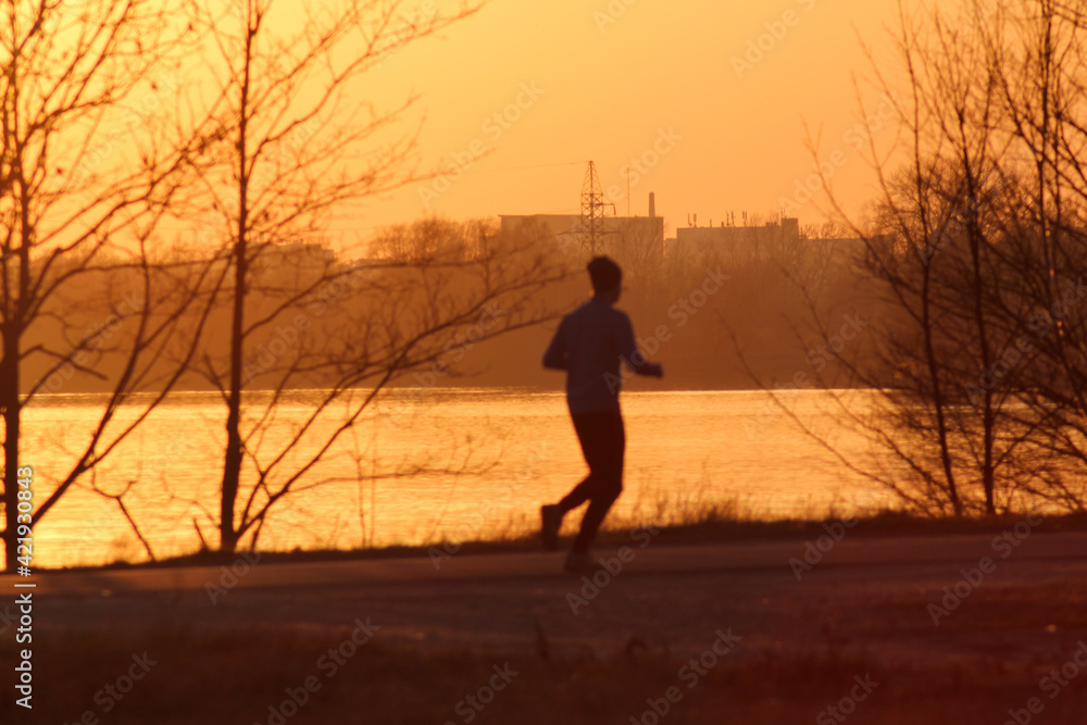Silhouette of a person jogging during sunset. Sport lifestyle concept
