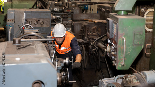 Mechanical engineer or worker in safety set working with heavy machine in a factory to check the production system. 
