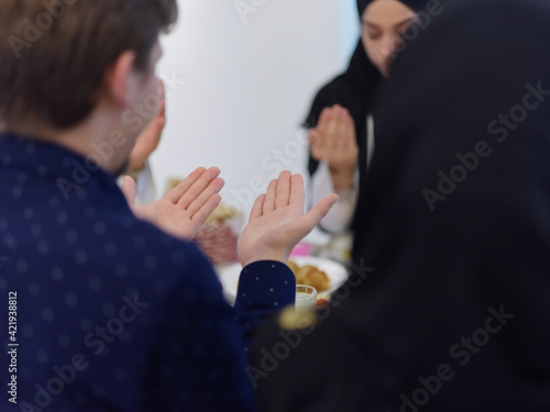 Fototapeta Naklejka Na Ścianę i Meble -  Muslim family making iftar dua to break fasting during Ramadan