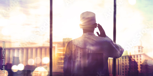 Double exposure of devout man doing azan
