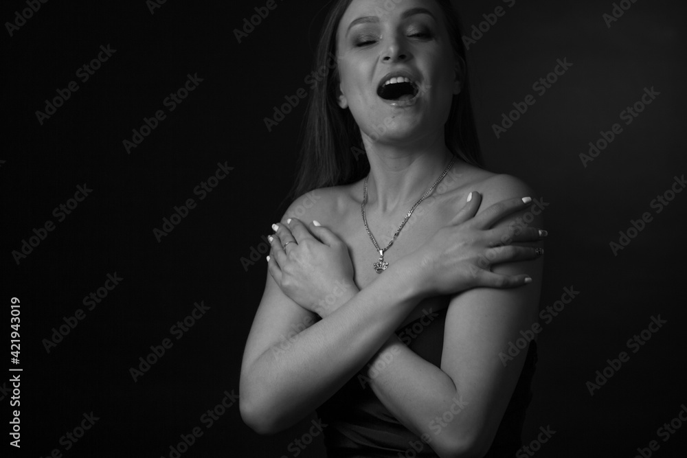black and white portrait of an adult woman in a studio on a black background. black and white portrait of an adult woman in a studio on a black background.