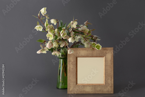 lenten flowers on the gray background in a vase and frame with place for the text invitation, menu
