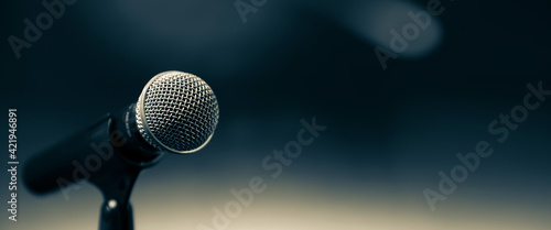 Public speaking backgrounds, Close-up the microphone on stand for speaker speech presentation stage performance with blur and bokeh light background.