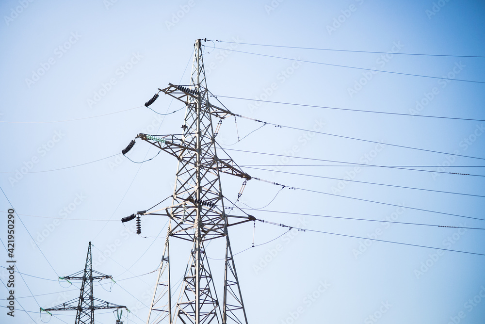 Metal supports of electric transmission lines on a blue sky background. Metal supports of electric transmission lines on a blue sky background.