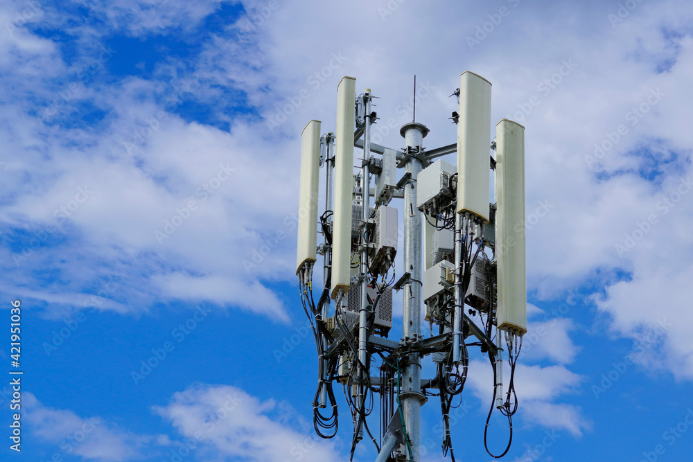 Telecommunication tower of 4G and 5G cellular. Macro Base Station. 5G radio network telecommunication equipment with radio modules and smart antennas mounted on a metal against cloulds sky background. Telecommunication tower of 4G and 5G cellular. Macro Base Station. 5G radio network telecommunication equipment with radio modules and smart antennas mounted on a metal against cloulds sky background.