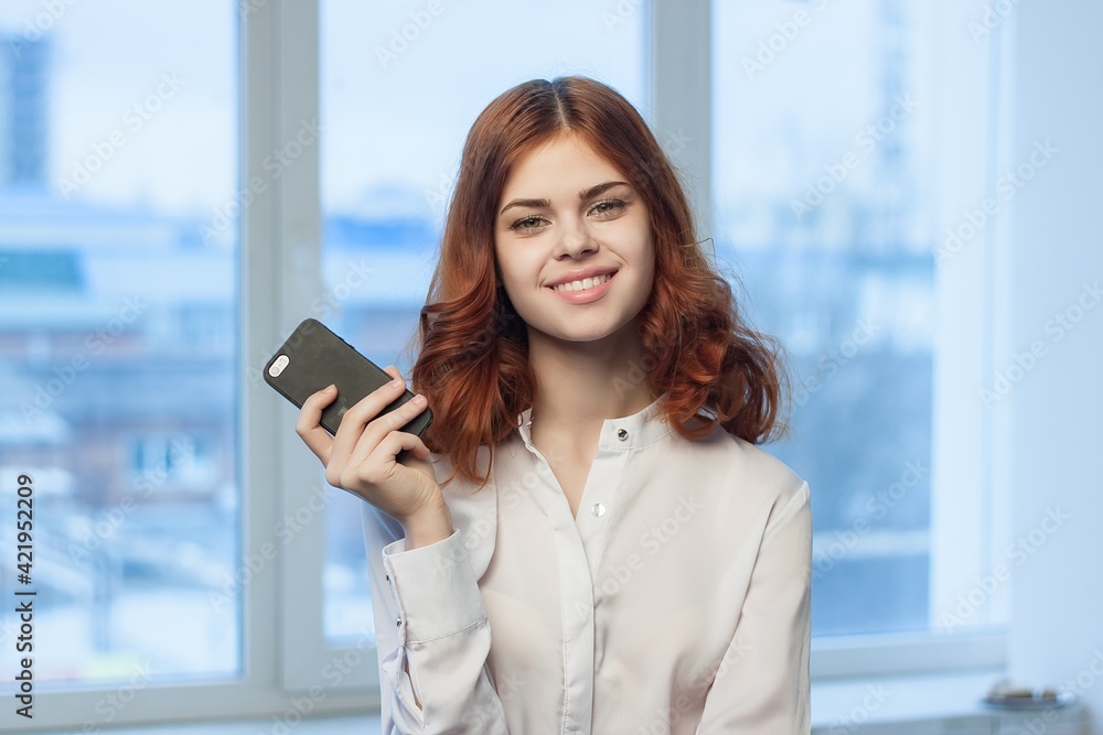 pretty woman in shirt with phone in hand communication Office professional