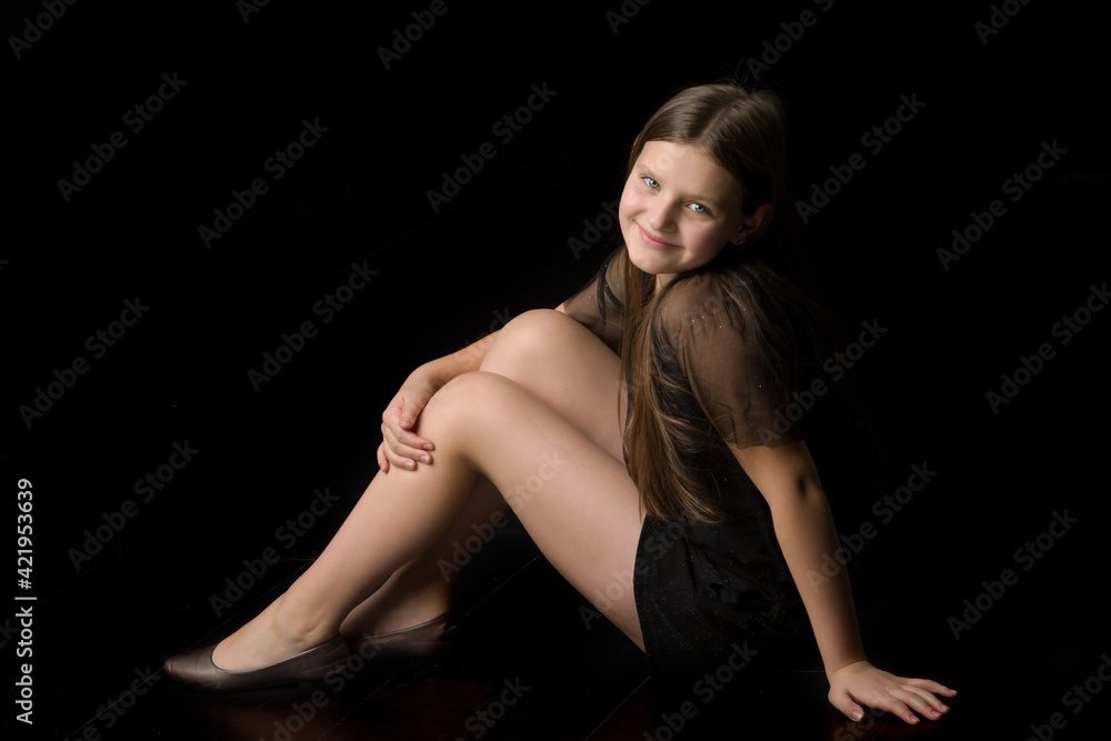 Smiling girl sitting on floor hugging her knees Smiling girl sitting on floor hugging her knees