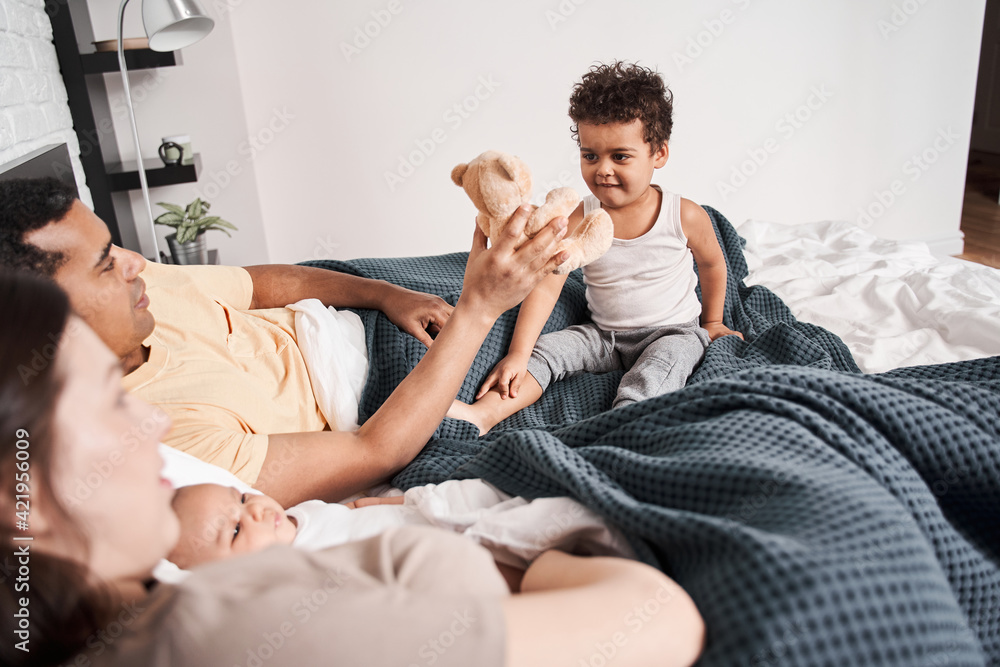 Family speaking with each other and playing with soft teddy bear Family speaking with each other and playing with soft teddy bear