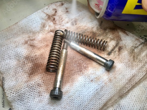 Rusty screws and springs. Anti-rust and corrosion sprays is apply to remove the rust effect.