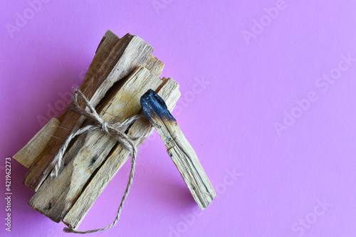 A close up image of healing smudge sticks on a purple background. 