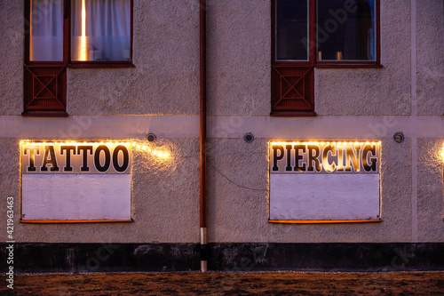 Photography Stockholm, Sweden A sign on the back of a residential building advertising piercing and tattoo