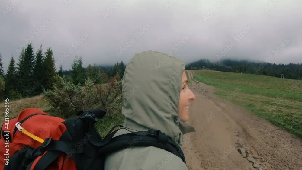 Hiking. A woman with a tourist backpack walks in bad weather. Hiking. A woman with a tourist backpack walks in bad weather.