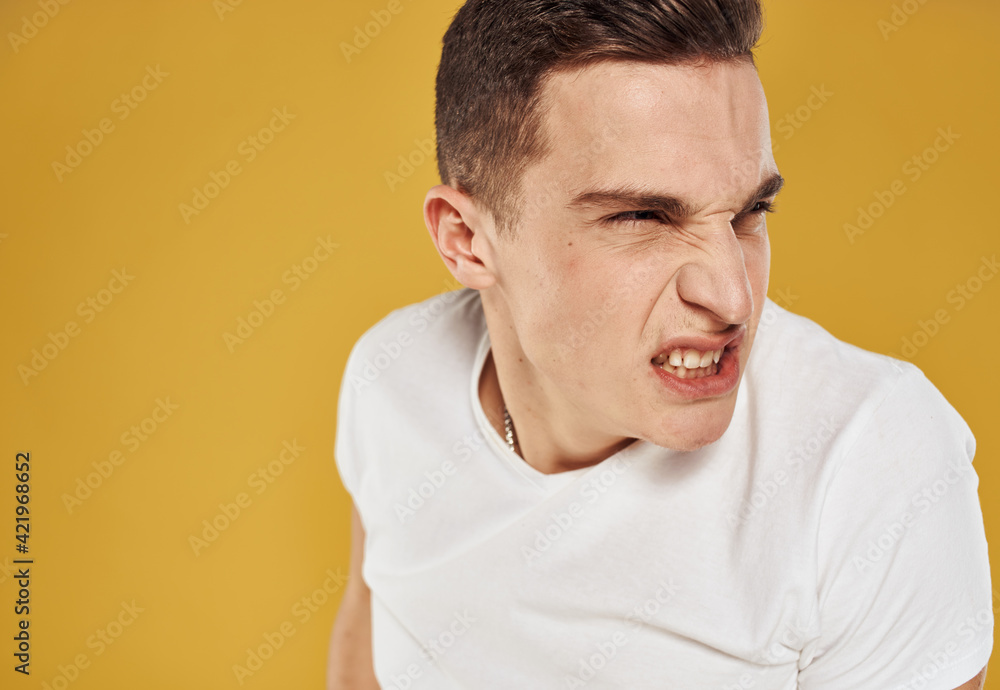 Guy portrait yellow background white t-shirt emotions model cropped view Guy portrait yellow background white t-shirt emotions model cropped view