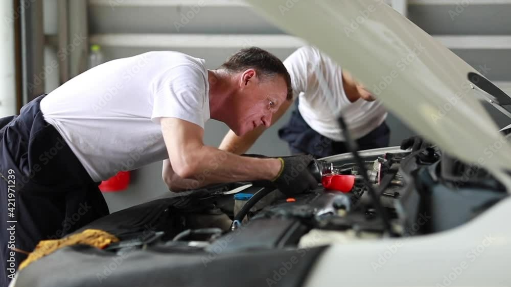 Pouring oil to car engine. Closue up male mechanic hand working and service in Car Service station Pouring oil to car engine. Closue up male mechanic hand working and service in Car Service station