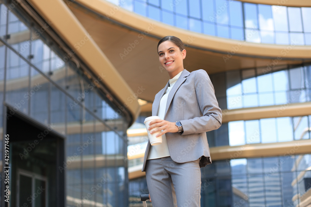 Portrait of successful business woman going to work with coffee walking near office building on city street. Portrait of successful business woman going to work with coffee walking near office building on city street.