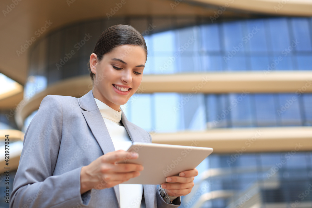 Obraz premium Business woman at work with tablet near office outdoors.