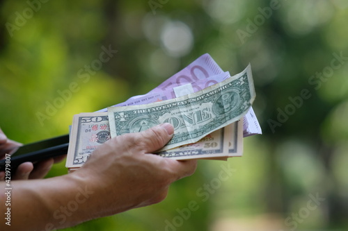 Hands holding money and concept saving money, business growth strategy of money concept, advertising banknote of finance and banking