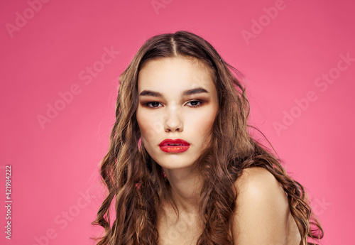 Pink background female portrait bared shoulders red lips