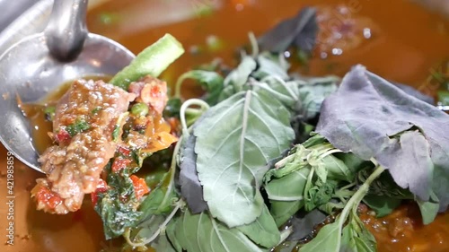 Close Up Footage of Hot and Spicy Beef Clear Soup Curry ( Kang Paa or Jungle Curry) With Long Curd Beans and Holy Basil Leaves, One of the Delicious Homemade Dish In Thailand photo