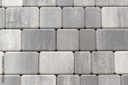 Paving stone surface. Color - shades of gray. Square and rectangular shape with rounded corners.