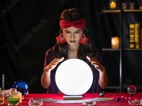 Asian fortune teller looking at crystal ball Fototapet