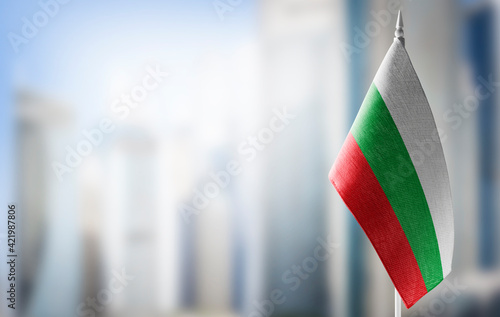 A small flag of Bulgaria on the background of a blurred background