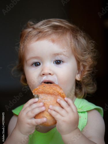 Baby with bread. Cute toddler child eating sandwich  self feeding concept.