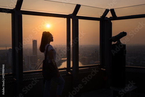 the silhouette of a girl standing on the observation deck and looking at the sunset © Павел Чигирь