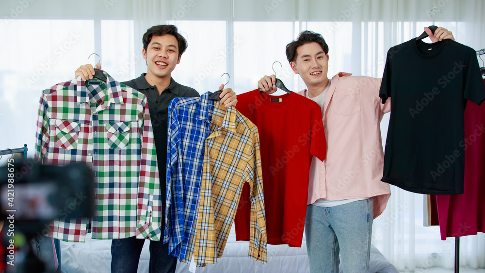 Happy Asian fashion bloggers showing garments
